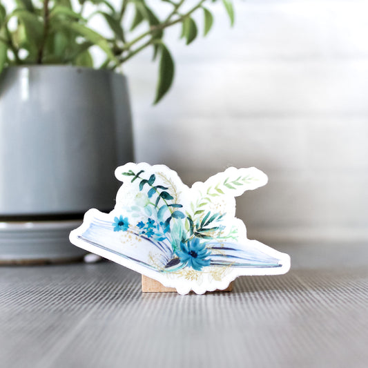 blue and teal flowers with various greens on top of an open book -- sticker design