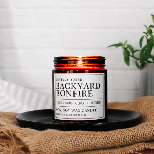 backyard bonfire soy wax candle in amber jar with black lid, campfire scented candle