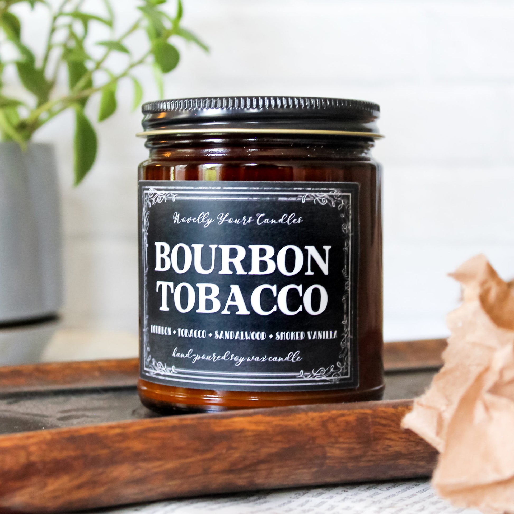 bourbon tobacco named candle in amber glass jar with black lid