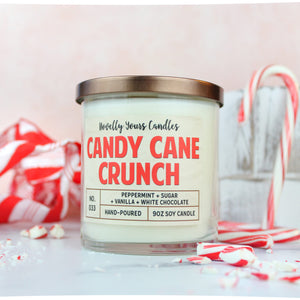 candy cane scented candle in clear glass tumbler jar with bronze lid, surrounded by candy canes