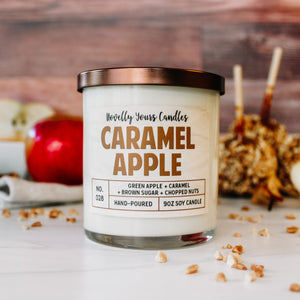 caramel apple scented candle by novelly yours. candle is in clear glass tumbler jar with bronze lid and caramel colored text.