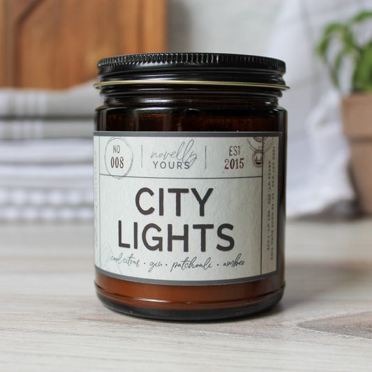 city lights scented soy wax candle in amber jar with black lid