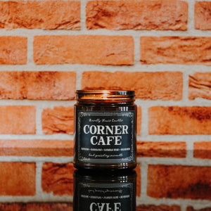 corner cafe coffee scented soy wax candle in amber jar, photo against red brick background