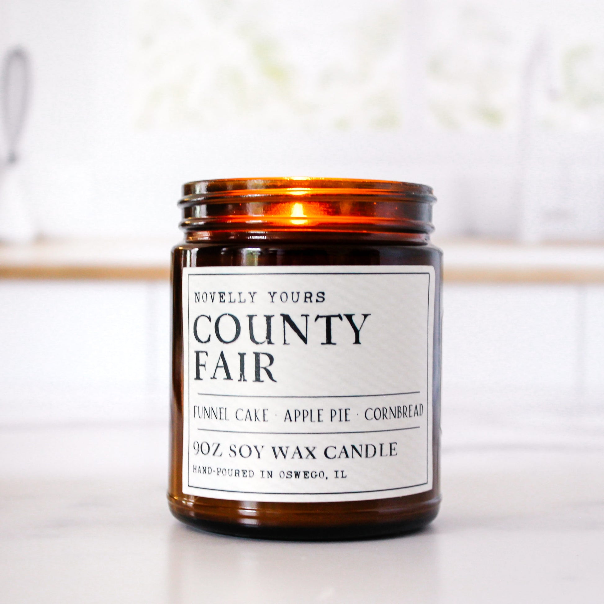 county fair bakery scented soy wax candle in amber jar sits against clean kitchen background