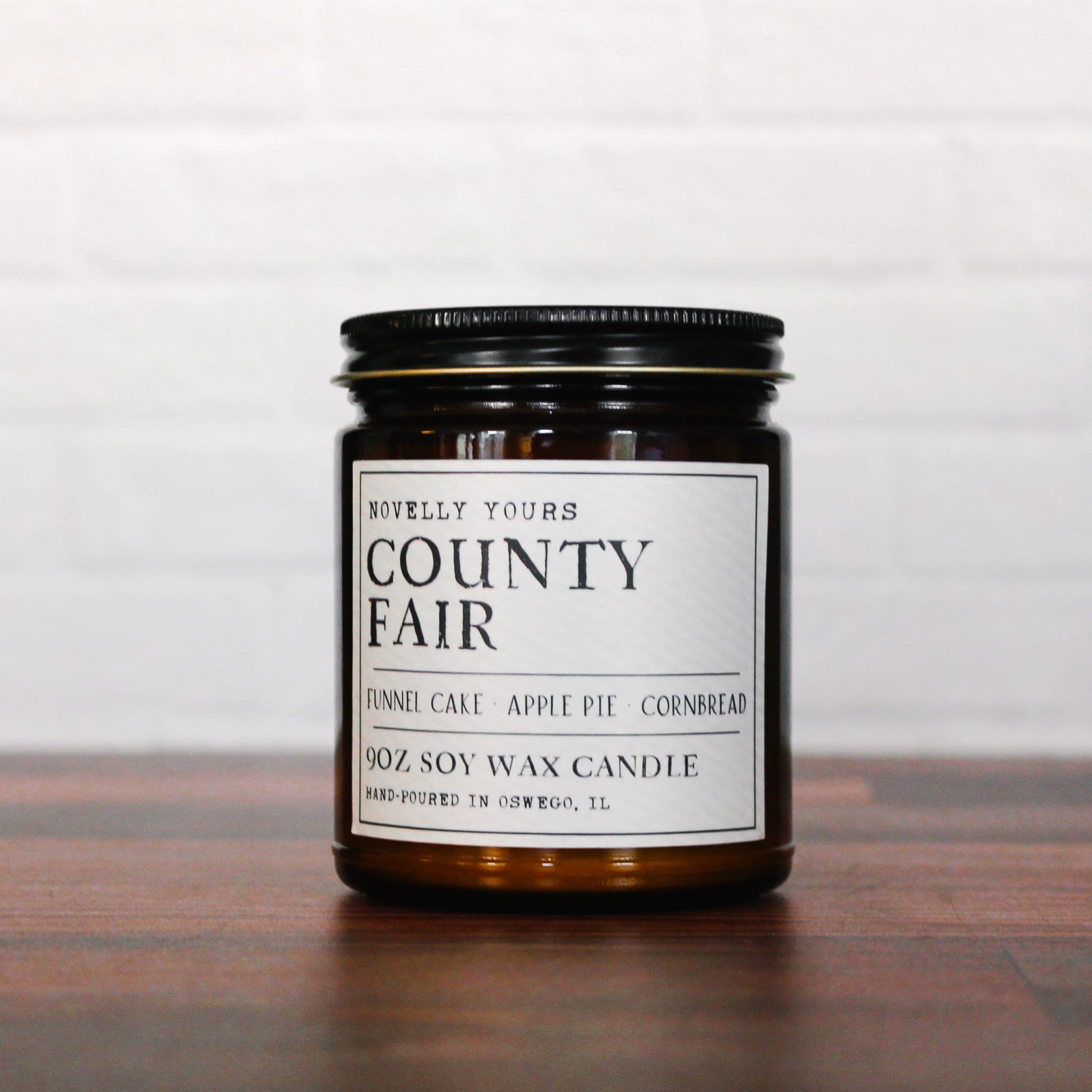 county fair bakery scented soy wax candle in amber jar, sits on wood base white background