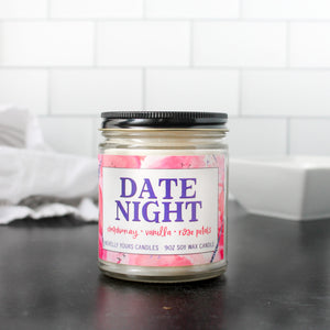 date night soy wax scented candle in clear glass jar with black lid, purple and pink label