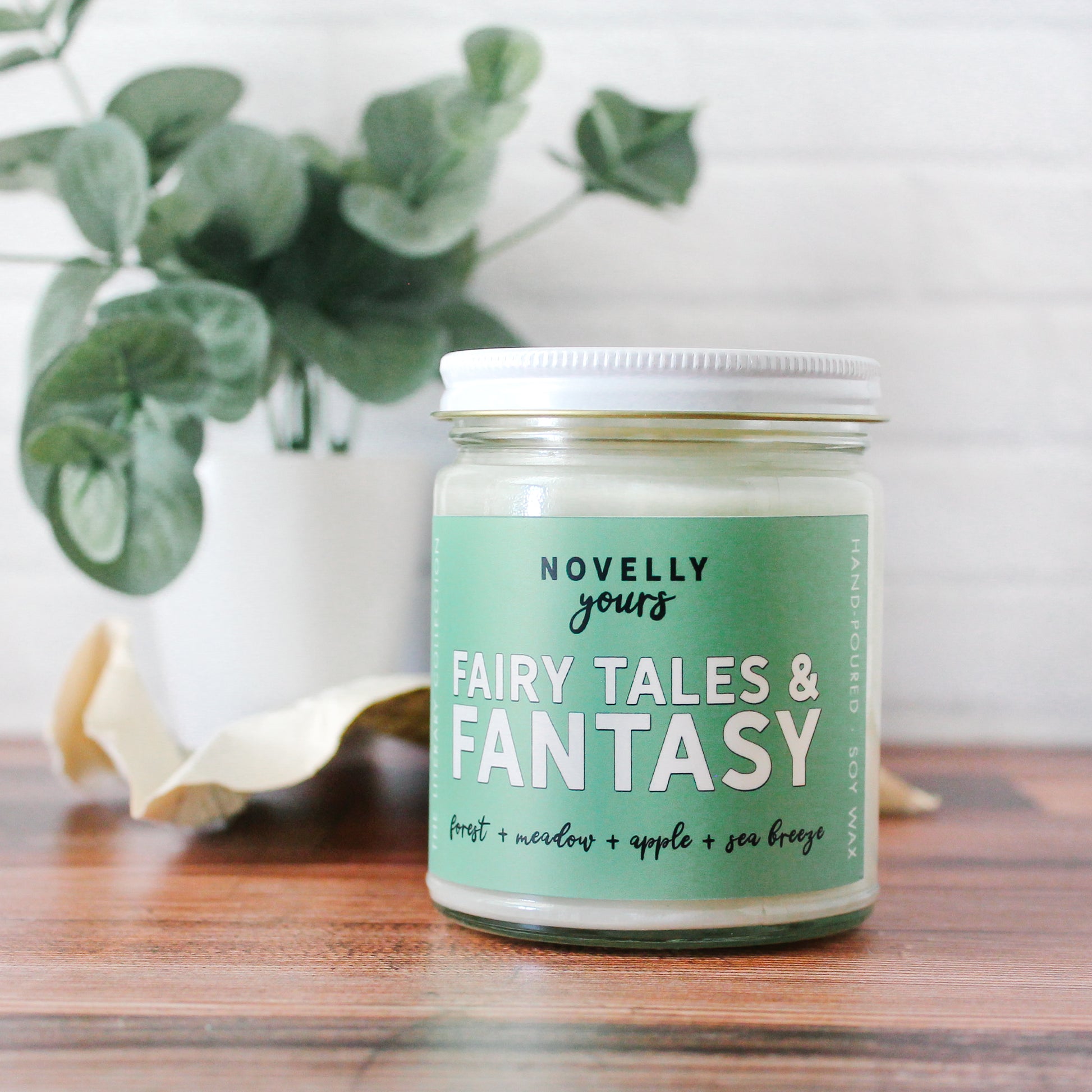 fairy tales & fantasy bookish candle with a green label and clear glass jar