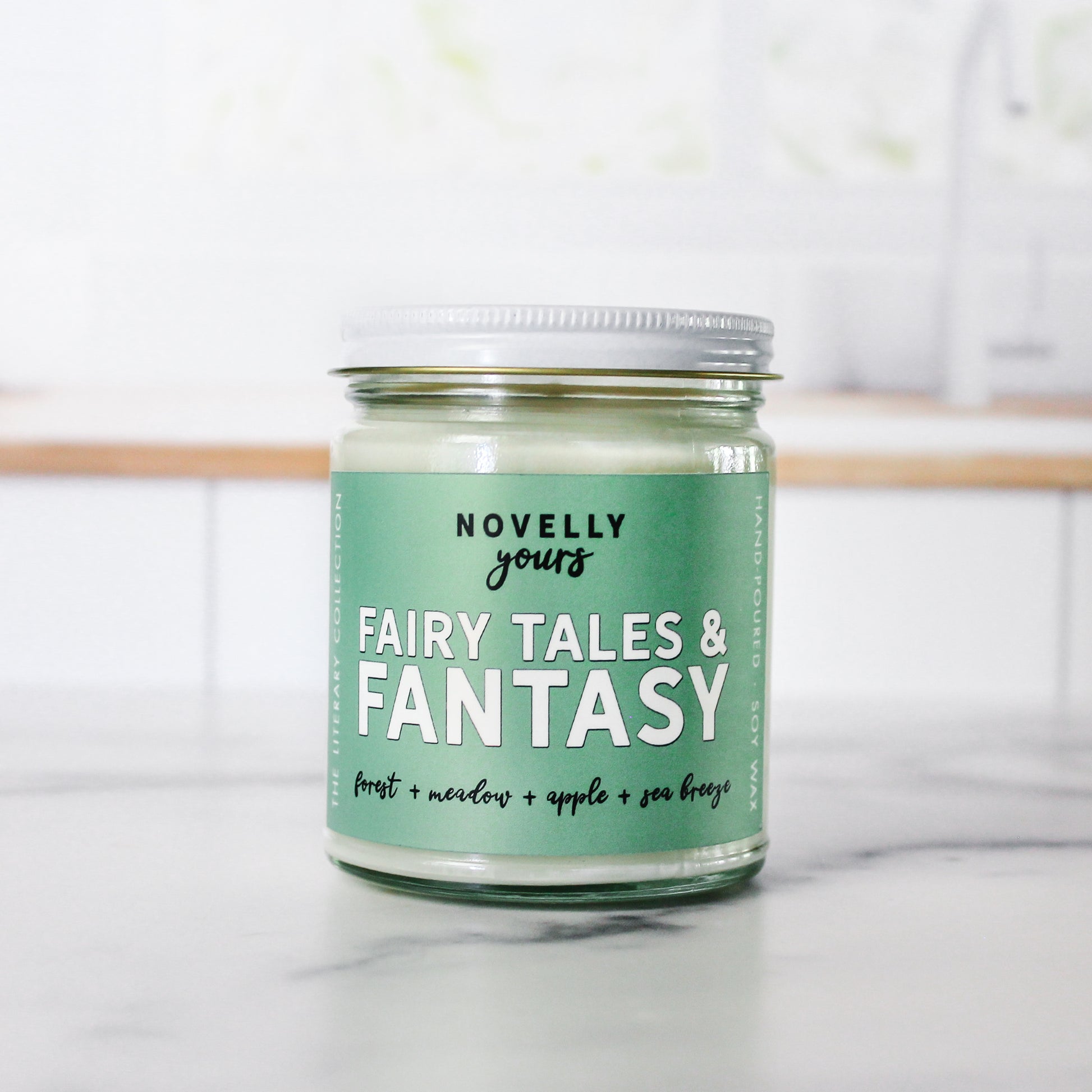 fairy tales & fantasy bookish candle with a green label and clear glass jar