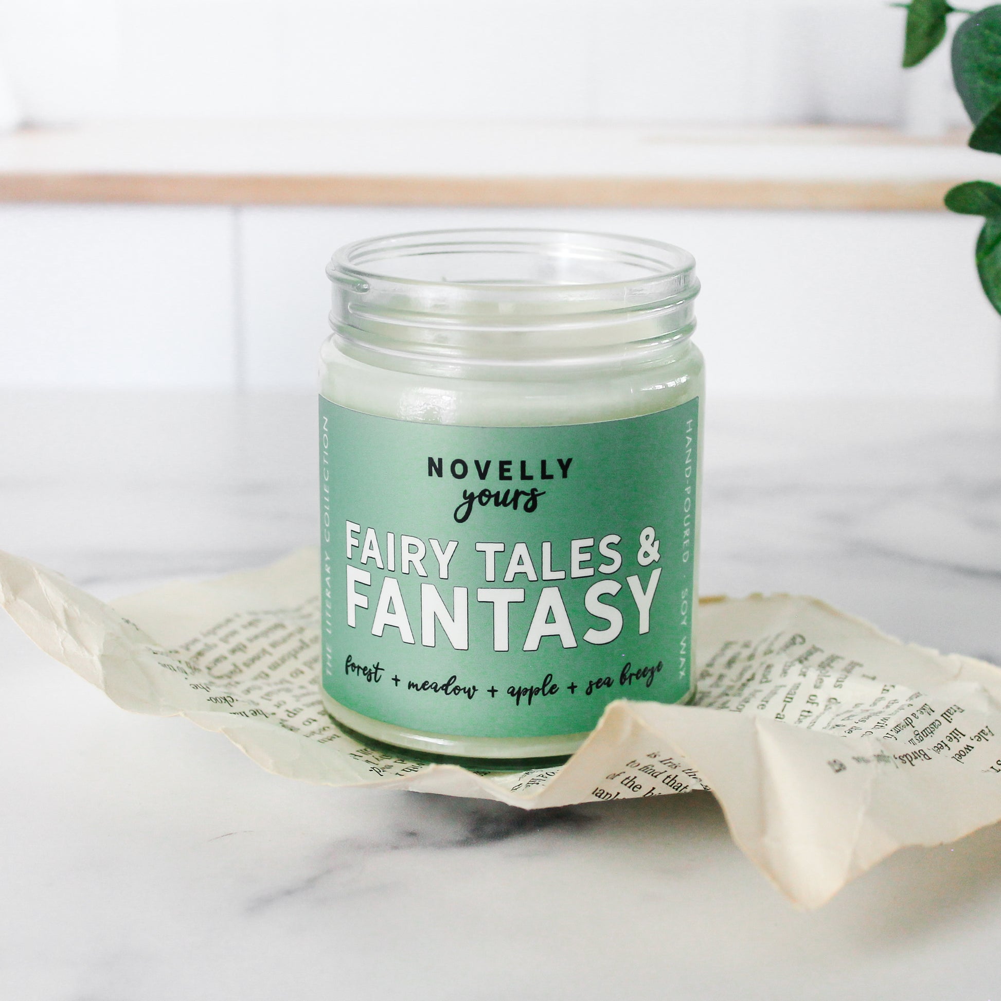 fairy tales & fantasy bookish candle with a green label and clear glass jar