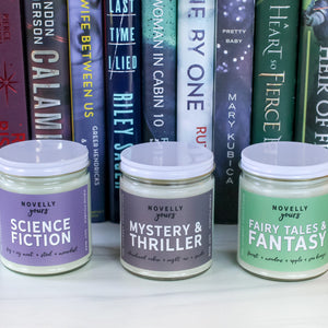literary candles sitting in front of book spines of coordination colors