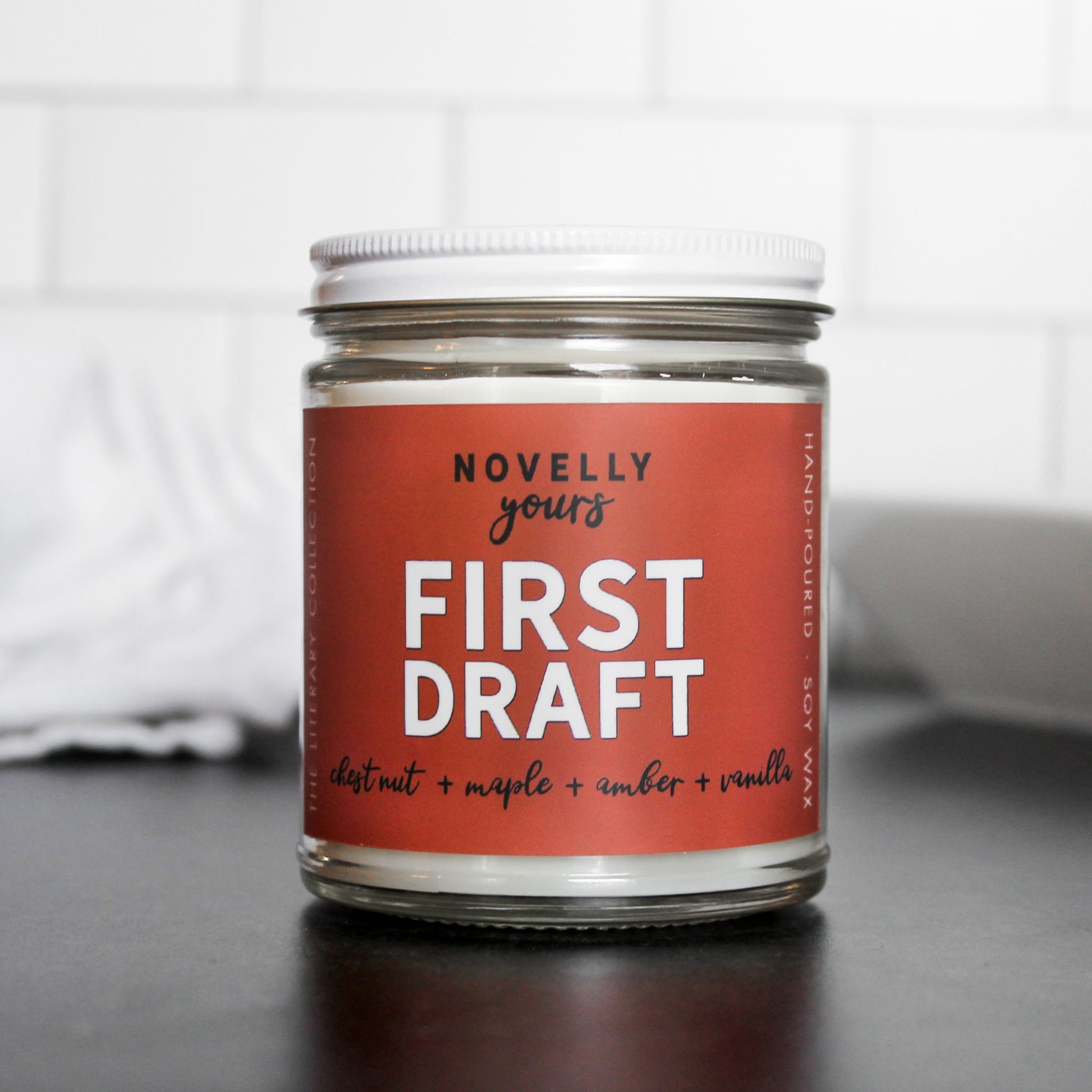 writing inspired scented candle called "First Draft" with Burnt orange label