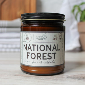 national forest scented soy wax candle in amber jar with black lid