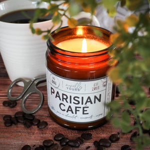 scented soy wax candle in amber jar, lit, surrounded by coffee beans reading 