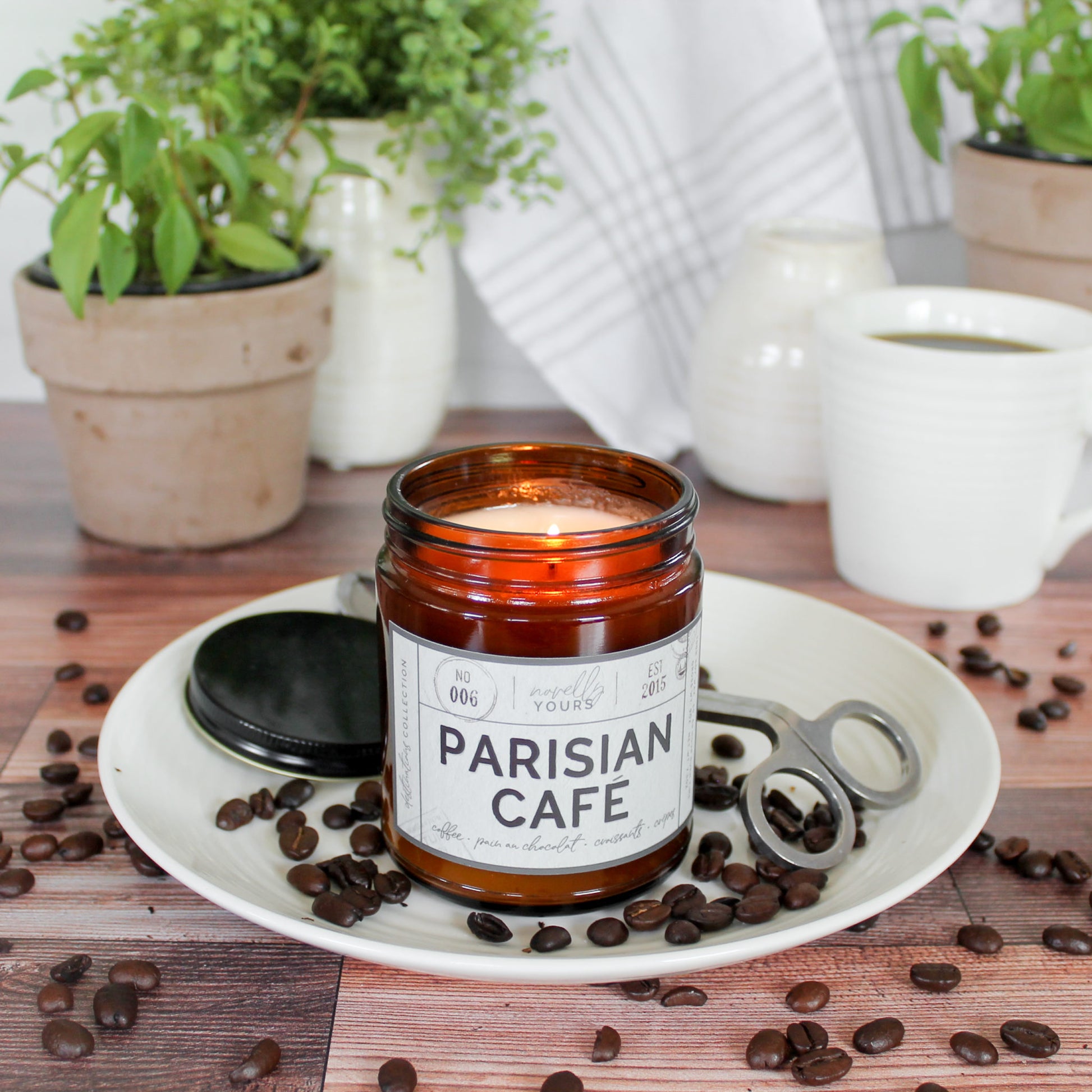 scented soy wax candle in amber jar, lit, surrounded by coffee beans reading "Parisian cafe"