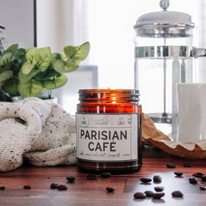 scented soy wax candle in amber jar, lit, surrounded by coffee beans reading 