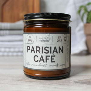 scented soy wax candle in amber jar with black lid reading 