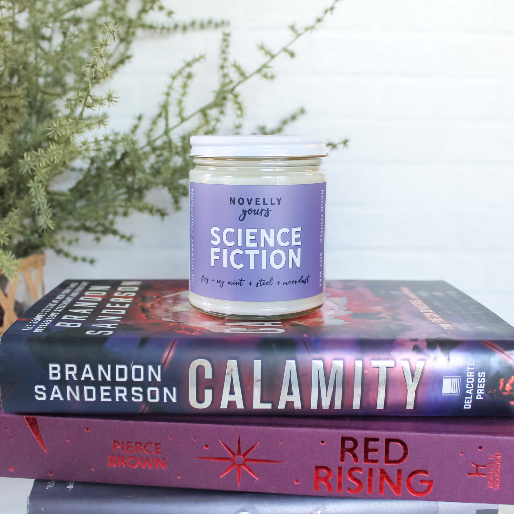 science fiction scented soy wax candle in clear glass jar with white lid and purple label
