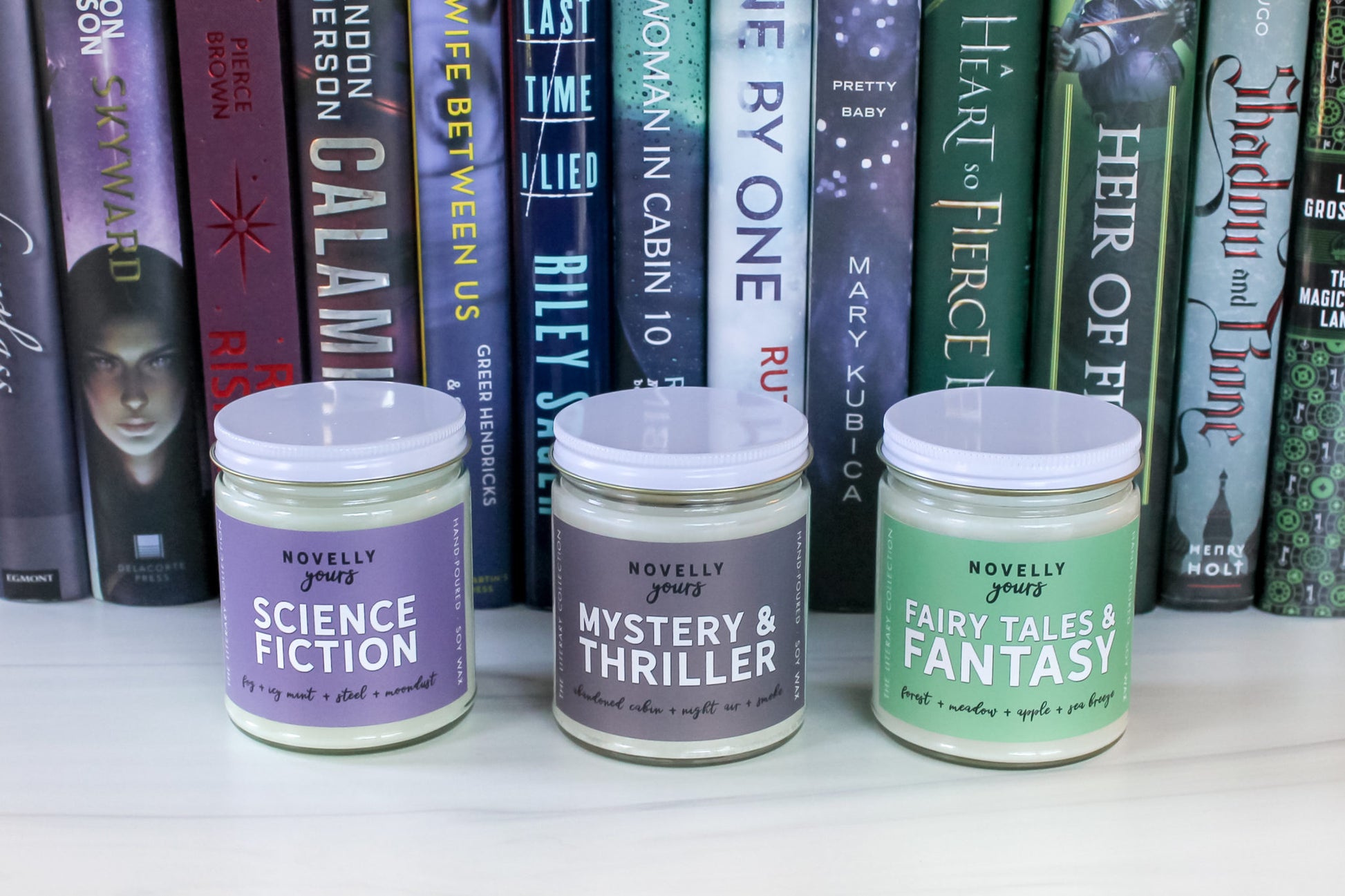 literary candles sitting in front of book spines of coordination colors