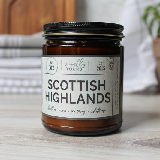 Scottish highlands scented soy wax candle in amber jar with black lid